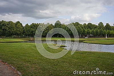 Schwerin, Germany - July 20, 2021 - The Castle Garden with statues and small bridges in the cloudy summer afternoon Stock Photo